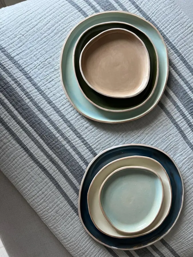 Juego de platos y bowls apilados en tonos tierra, verde y azul