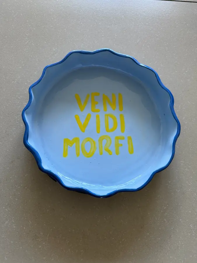 Plato de cerámica azul con la frase Veni Vidi Morfi en amarillo