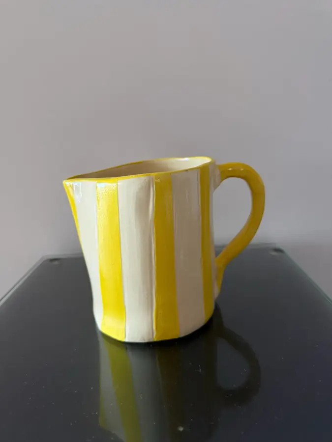 Taza de cerámica con rayas amarillas y blancas