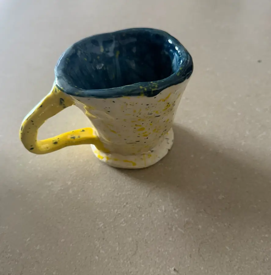 Taza de cerámica blanca con interior azul y salpicaduras